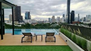two chairs and a table on a balcony with a view of a city at The SACHA Apart-Hotel Thonglor Sukhumvit Bangkok in Bangkok