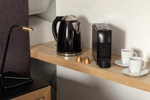 Eine Kaffeemaschine und Tassen auf einem Holzregal in der Unterkunft 4 SMART HOTEL in Olomouc