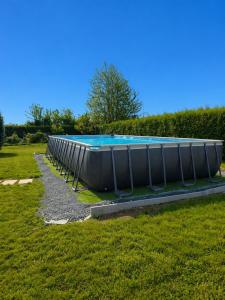 a large swimming pool in a grass field at Le Clos de Valletot in Valletot