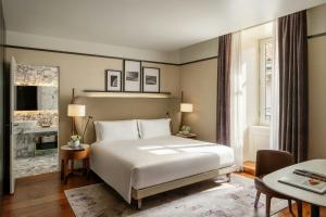 a bedroom with a white bed and a bathroom at Mandarin Oriental, Milan in Milan