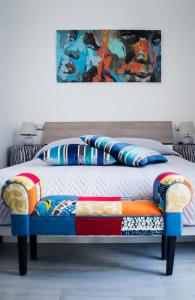 um quarto com uma cama com um banco com um quadro em Brezza Marina B&B em Barletta