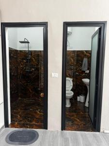 a bathroom with two glass doors and a toilet at Forum View 2 in Durrës +8 photos