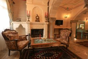 a living room with two chairs and a fireplace at Hasan Bey Konakları in Avanos