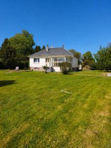 a white house with a large grassy yard at Le Clos de Valletot in Valletot