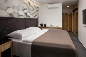 ein Schlafzimmer mit einem großen Bett und weißen Kissen in der Unterkunft 4 SMART HOTEL in Olomouc