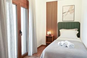 a bedroom with a bed with towels on it at Lambda Luxury Villa 2 in Syvota +36 photos
