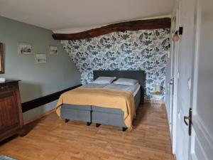 a bedroom with a bed with a patterned wall at Le figuier in Benayes