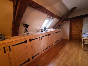 a kitchen with wooden cabinets in a room with a window at Le figuier in Benayes