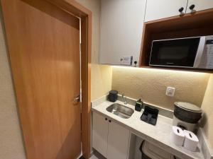 a kitchen with a sink and a microwave at Studios 138 in Belém