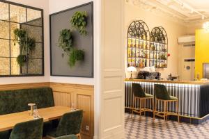 a restaurant with green chairs and a bar at Hotel Traugutta 12 in Łódź