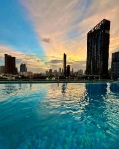 a swimming pool with a city skyline in the background at The SACHA Apart-Hotel Thonglor Sukhumvit Bangkok in Bangkok