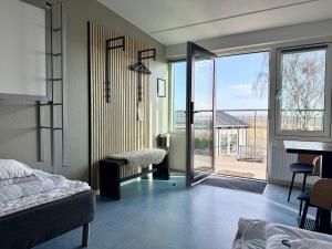 a bedroom with a bed and a sliding glass door at Danhostel Rønde in Rønde