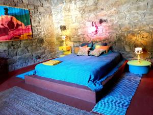 a bedroom with a bed in a stone wall at Quinta Maravista in Faial da Terra
