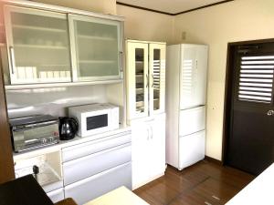 a kitchen with a white refrigerator and a microwave at ビレッジ幸 in Otsu +16 photos