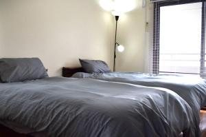 a bedroom with two beds and a lamp and a window at ビレッジ幸 in Otsu
