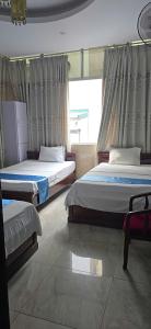 a bedroom with two beds and a window at Gia An Hotel in Hanoi