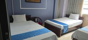 two beds in a small room with blue walls at Gia An Hotel in Hanoi