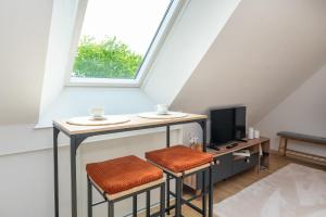a room with a table with two stools and a tv at Chambre d'hôtes reflets du Golfe in Arradon