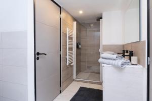 a bathroom with a walk in shower next to a glass door at Chambre d'hôtes reflets du Golfe in Arradon +43 photos