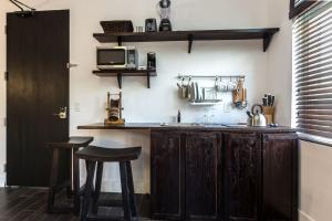 a kitchen with a counter with two stools and a microwave at Vive Zen Queen Room in Miami