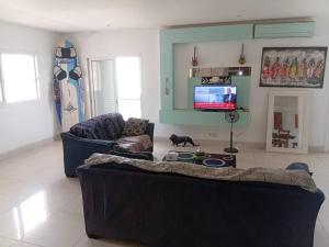 a living room with a couch and a flat screen tv at New White House in Saly Portudal
