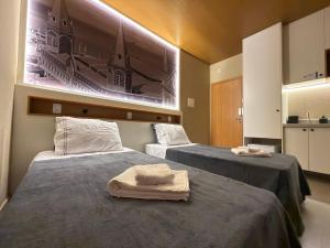 two beds in a room with towels on them at Studios 138 in Belém