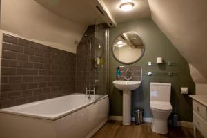 a bathroom with a sink and a tub and a toilet at The Woolpack Hotel in Tenterden +91 photos