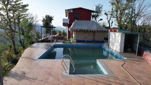 a swimming pool on a patio next to a house at Ransuli mountain retreat in Dehradun