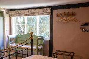 a bedroom with a window and a crib in a room at The Woolpack Hotel in Tenterden