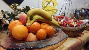 un bol de fruta con plátanos y naranjas sobre una mesa en Bonsaï Hotel d'Orleans, en Olivet 18 fotos más