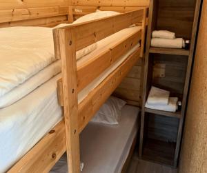 a bunk bed room with two bunk beds and towels at Urban gardens Ieper - Basic blokhut in Ieper