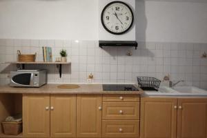 a kitchen with a clock on the wall and a sink at Charming accommodation for 2 people in ELNE in Elne
