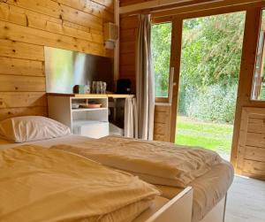 a bedroom with a bed and a large window at Urban gardens Ieper - Basic blokhut in Ieper