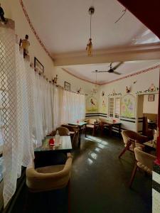 a living room with curtains and tables and chairs at L2 Darbar Kothi Heritage Living in Jodhpur