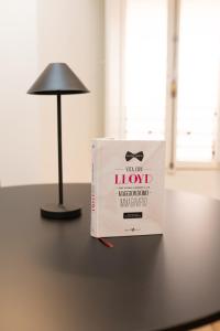 a book sitting on a table next to a lamp at GL Suite Via Baglioni in Perugia