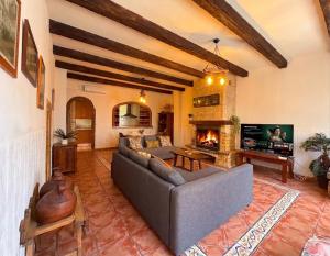 a living room with a couch and a fireplace at Casa Rural con Encanto Chimenea y Parking in Güéjar-Sierra