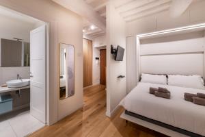 a white bedroom with a bed and a sink at GL Suite Via Baglioni in Perugia