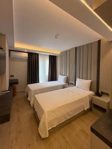 ein Hotelzimmer mit zwei Betten und einem Fernseher in der Unterkunft Kayalar Hotel in Antalya + 46 Fotos
