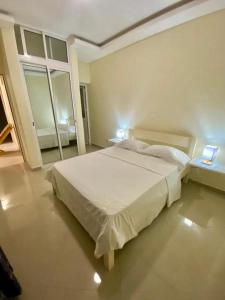 a bedroom with a large white bed and a window at Monte Do Bem-Estar Tarrafal in Tarrafal