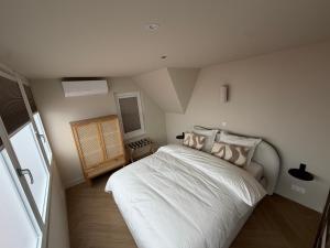 a bedroom with a white bed in a room at Breeze Inn B&B in Oegstgeest