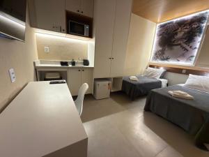 a small room with two beds and a table at Studios 138 in Belém