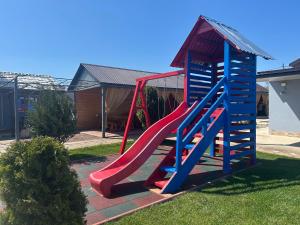 a playground with a slide in a yard at Cazare Nicoleta in Vadu