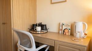 a desk with a white chair and a wooden table at Tharsh Peaceful Escape Double Room with Shared Bathroom in Coundon