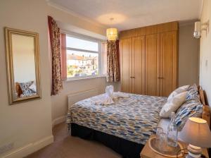 a small bedroom with a bed and a window at Tharsh Peaceful Escape Double Room with Shared Bathroom in Coundon