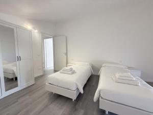 a white room with two beds and a mirror at Country Escape in Poggio Renatico