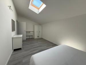 a white bedroom with a bed and a skylight at Country Escape in Poggio Renatico
