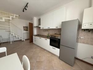 a kitchen with white cabinets and a refrigerator at Country Escape in Poggio Renatico