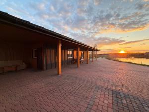 a building with a sunset in the background at Domek na łowisku in Adamówka