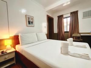a hotel room with a large white bed and a mirror at ZKB Twins Hotel in General Santos
