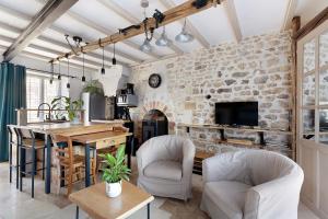 a kitchen and living room with a stone wall at Gite À La Tite Boulite in Vouneuil-sous-Biard